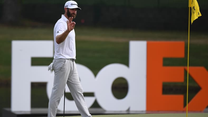 Aug 7, 2021; Memphis, Tennessee, USA; Dustin Johnson waives to the crowd as he approaches the 18th green during the third round of the WGC FedEx St. Jude Invitational golf tournament at TPC Southwind. Mandatory Credit: Christopher Hanewinckel-USA TODAY Sports