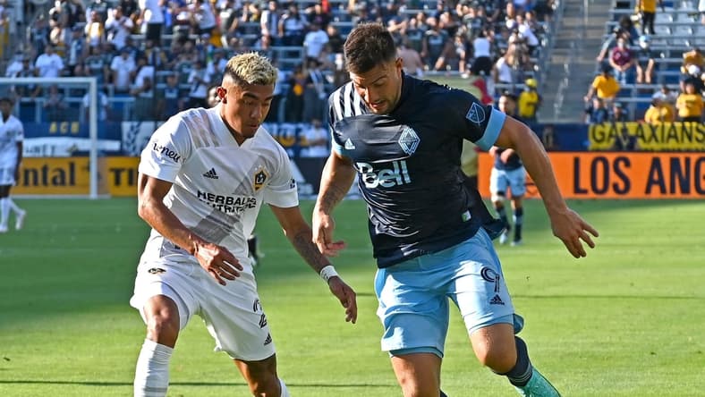 Aug 8, 2021; Carson, California, USA; Los Angeles Galaxy defender Julian Araujo (2) guards Vancouver Whitecaps forward Lucas Cavallini (9) as he takes the ball toward the goal in the first half of the game at Dignity Health Sports Park Center. Mandatory Credit: Jayne Kamin-Oncea-USA TODAY Sports