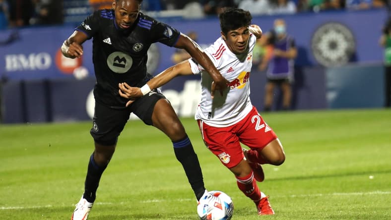 Aug 14, 2021; Montreal, Quebec, CAN; CF Montreal forward Mason Toye (13) and New York Red Bulls midfielder Omir Fernandez (21) battle for the ball during the second half at Stade Saputo. Mandatory Credit: Jean-Yves Ahern-USA TODAY Sports