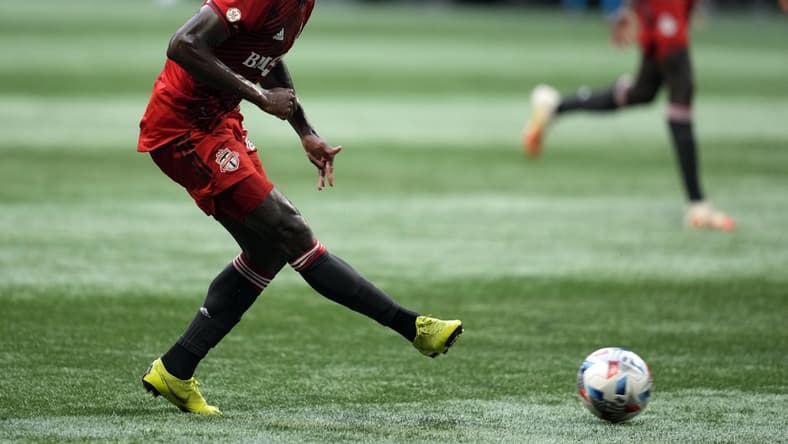 Aug 18, 2021; Atlanta, Georgia, USA; Toronto FC midfielder Richie Laryea (22) kicks the ball against the Atlanta United during the first half at Mercedes-Benz Stadium. Mandatory Credit: Dale Zanine-USA TODAY Sports