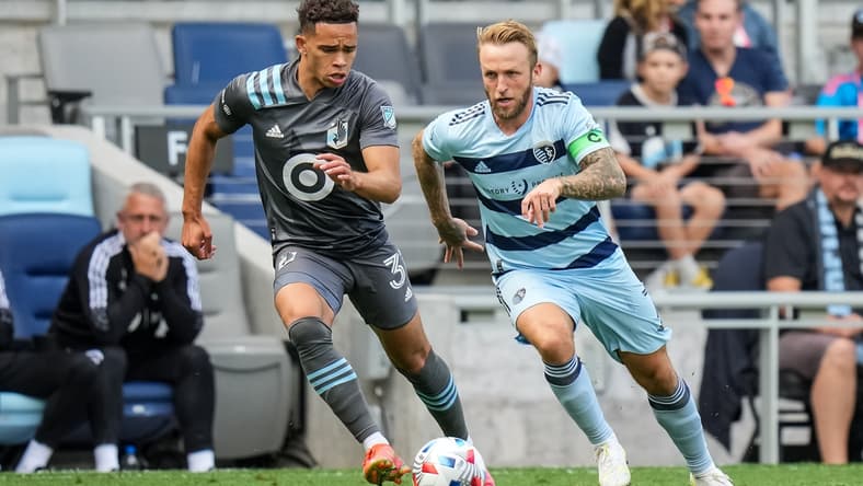 Aug 21, 2021; Saint Paul, MN, USA; Sporting Kansas City forward Johnny Russell (7) dribbles past Minnesota United midfielder Hassani Dotson (31) during the first half at Allianz Field. Mandatory Credit: Brace Hemmelgarn-USA TODAY Sports