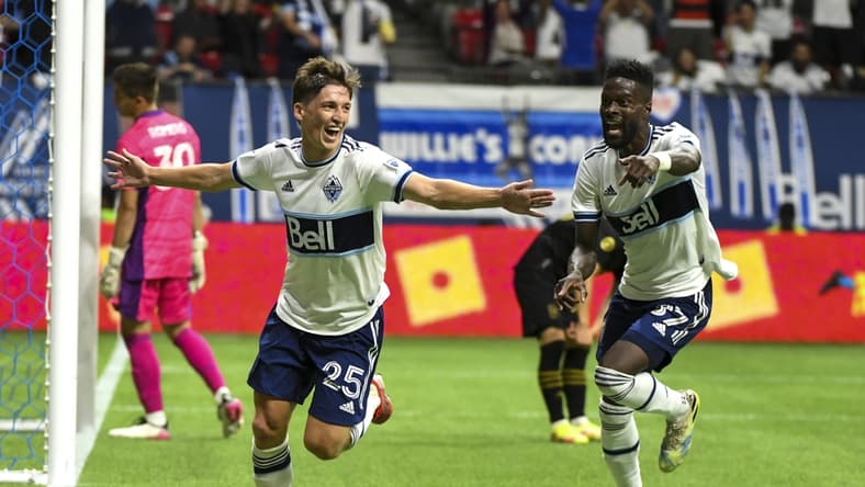 Aug 21, 2021; Vancouver, British Columbia, CAN; Vancouver Whitecaps midfielder Ryan Gauld (25) scores against Los Angeles FC goalkeeper Tomas Romero (30) during the second half at BC Place. Mandatory Credit: Anne-Marie Sorvin-USA TODAY Sports