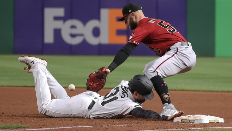 Aug 25, 2021; Pittsburgh, Pennsylvania, USA; Pittsburgh Pirates second baseman Michael Chavis (31) dives back safely to first base as Arizona Diamondbacks first baseman Christian Walker (53) takes a pick-off attempt how during the fifth inning at PNC Park. Mandatory Credit: Charles LeClaire-USA TODAY Sports