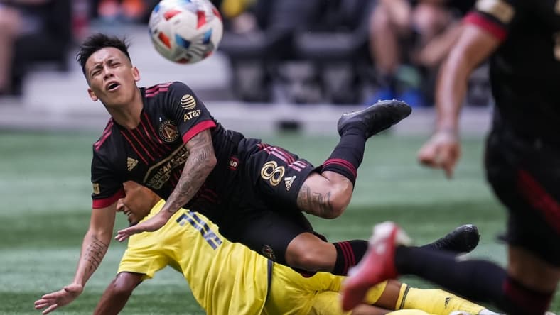 Aug 28, 2021; Atlanta, Georgia, USA; Atlanta United midfielder Ezequiel Barco (8) flies over Nashville SC midfielder Hany Mukhtar (10) after playing the ball during the first half at Mercedes-Benz Stadium. Mandatory Credit: Dale Zanine-USA TODAY Sports