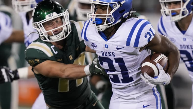 Sep 3, 2021; Charlotte, North Carolina, USA; Duke Blue Devils running back Mataeo Durant (21) is tackled by Charlotte 49ers linebacker Luke Martin (17) during the second quarter at Jerry Richardson Stadium. Mandatory Credit: Jim Dedmon-USA TODAY Sports