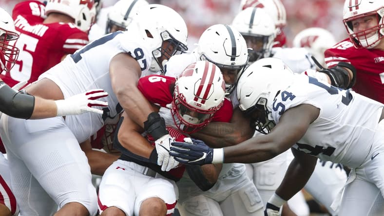Sep 4, 2021; Madison, Wisconsin, USA;  Wisconsin Badgers running back Chez Mellusi (6) is tackled with the football during the first quarter against the Penn State Nittany Lions at Camp Randall Stadium. Mandatory Credit: Jeff Hanisch-USA TODAY Sports