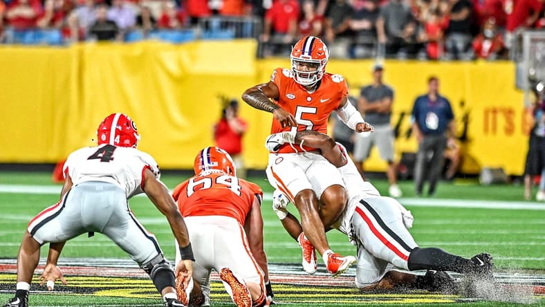 zSep 4, 2021; Charlotte, North Carolina, USA; Clemson Tigers quarterback D.J. Uiagalelei (5) is hit while he throws the ball during the second quarter against the Georgia Bulldogs at Bank of America Stadium. Mandatory Credit: Griffin Zetterberg-USA TODAY Sports