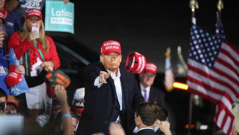 U.S. President Donald Trump tosses a Make America Great Again hat into a crowd of thousands after speaking at the Des Moines International Airport during a rally in Iowa on Wednesday, Oct. 14, 2020.
20201014 Trumpiowa
