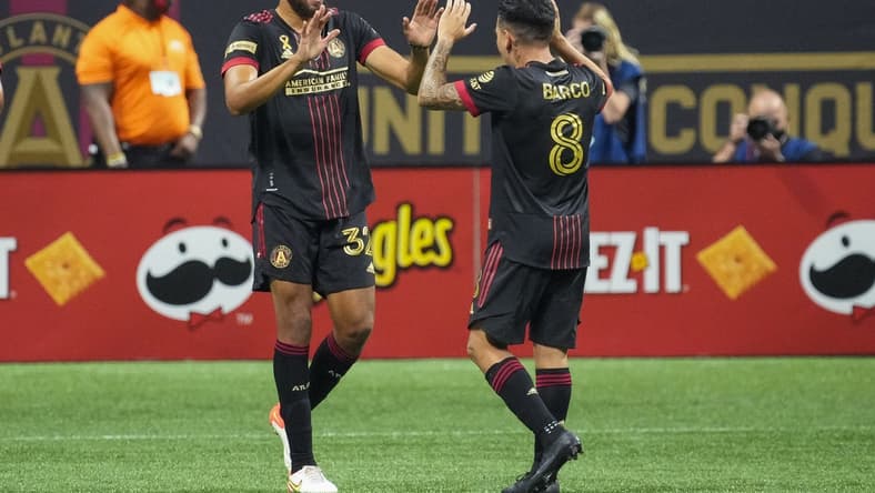 Sep 10, 2021; Atlanta, Georgia, USA; Atlanta United defender George Campbell (32) reacts with midfielder Ezequiel Barco (8) after scoring a goal against Orlando City during the first half at Mercedes-Benz Stadium. Mandatory Credit: Dale Zanine-USA TODAY Sports