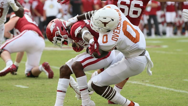 Sep 11, 2021; Fayetteville, Arkansas, USA; Texas Longhorns linebacker DeMarvion Overshow (0) tackles Arkansas Razorbacks running back Trelon Smith (22) during the first quarter at Donald W. Reynolds Razorback Stadium. Mandatory Credit: Nelson Chenault-USA TODAY Sports