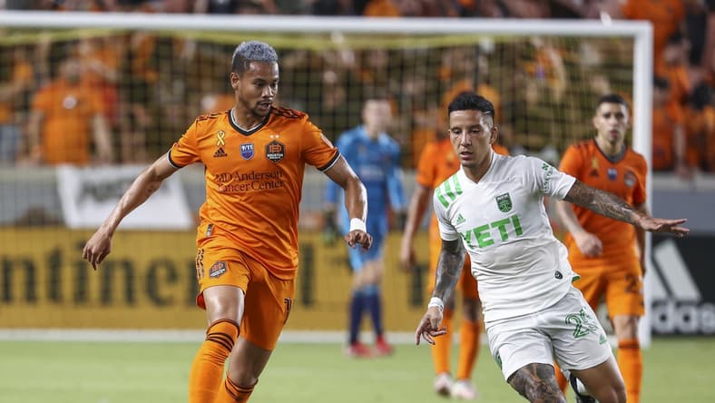 Sep 11, 2021; Houston, Texas, USA; Houston Dynamo FC forward Ariel Lassiter (11) advances the ball as Austin FC midfielder Sebastian Driussi (25) defends during the second half at BBVA Stadium. Mandatory Credit: Troy Taormina-USA TODAY Sports