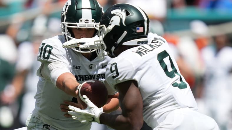 Sep 18, 2021; Miami Gardens, Florida, USA; Michigan State Spartans quarterback Payton Thorne (10) hands the ball to running back Kenneth Walker III (9) during the first half against the Miami Hurricanes at Hard Rock Stadium. Mandatory Credit: Jasen Vinlove-USA TODAY Sports