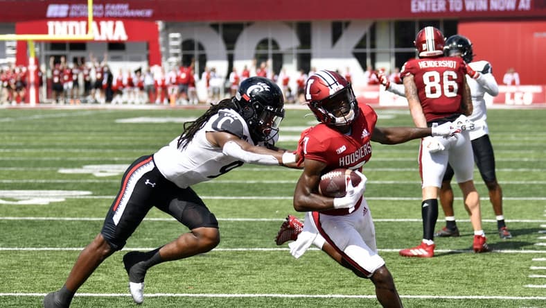 Sep 18, 2021; Bloomington, Indiana, USA; Indiana Hoosiers wide receiver D.J. Matthews Jr. (7) runs the ball into the end zone for a touchdown against Cincinnati Bearcats cornerback Arquon Bush (9) during the second half at Memorial Stadium. Bearcats won 38-24. Mandatory Credit: Marc Lebryk-USA TODAY Sports