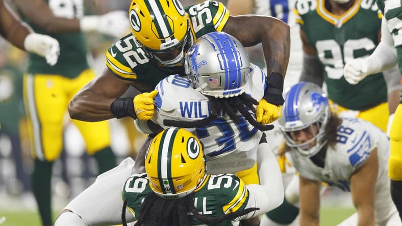 Sep 20, 2021; Green Bay, Wisconsin, USA; Detroit Lions running back Jamaal Williams (30) is tackled by Green Bay Packers outside linebackers Rashan Gary (52) and Isaiah McDuffie (58) during the first quarter at Lambeau Field. Mandatory Credit: Jeff Hanisch-USA TODAY Sports