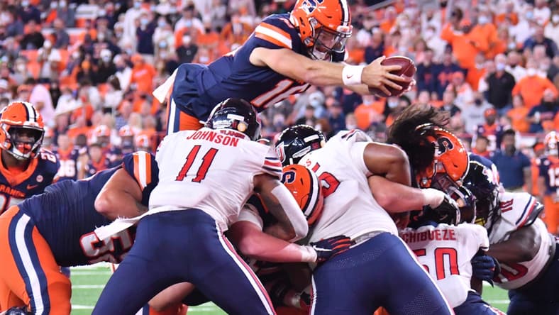 Sep 24, 2021; Syracuse, New York, USA; Syracuse Orange quarterback Garrett Shrader (16) leaps over the line of scrimmage to score a touchdown against the Liberty Flames in the second quarter at the Carrier Dome. Mandatory Credit: Mark Konezny-USA TODAY Sports