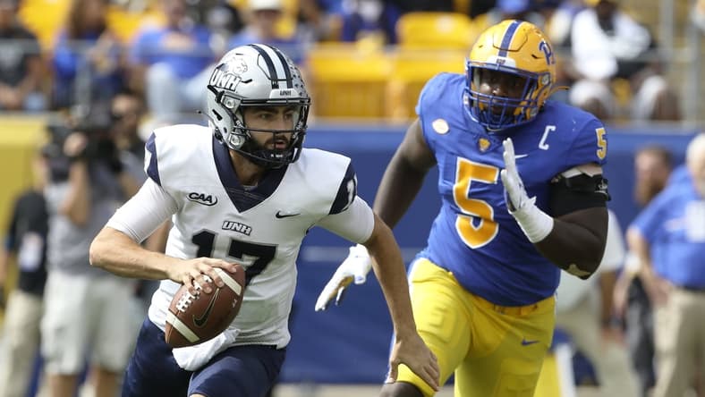 Sep 25, 2021; Pittsburgh, Pennsylvania, USA; New Hampshire Wildcats quarterback Bret Edwards (17) scrambles with the ball as Pittsburgh Panthers defensive lineman Deslin Alexandre (5) chases during the second quarter at Heinz Field. Mandatory Credit: Charles LeClaire-USA TODAY Sports