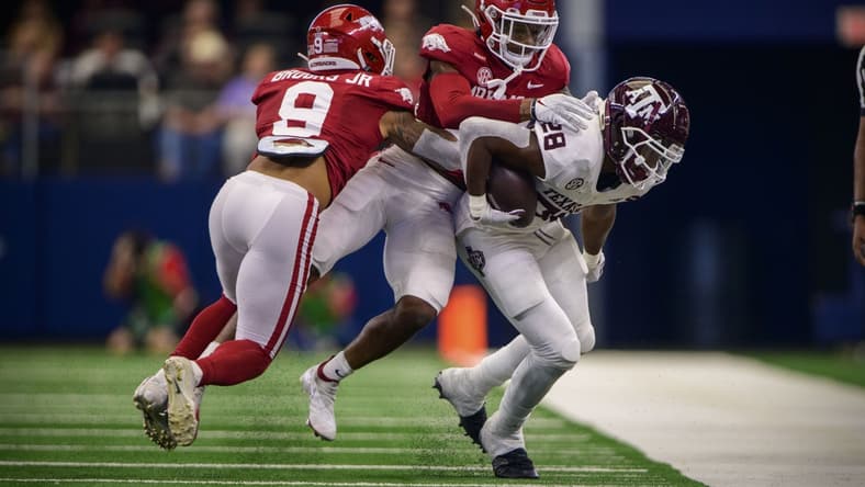 Sep 25, 2021; Arlington, Texas, USA; Arkansas Razorbacks defensive back Greg Brooks Jr. (9) and defensive back LaDarrius Bishop (24) tackle Texas A&M Aggies running back Isaiah Spiller (28) during the first quarter at AT&T Stadium. Mandatory Credit: Jerome Miron-USA TODAY Sports