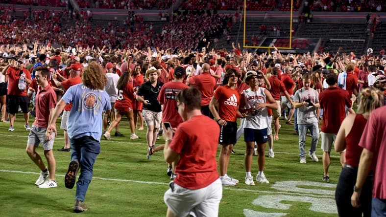 Sep 25, 2021; Raleigh, North Carolina, USA; North Carolina State Wolfpack fans storm the field after a win against the Clemson Tigers at Carter-Finley Stadium. Mandatory Credit: Rob Kinnan-USA TODAY Sports