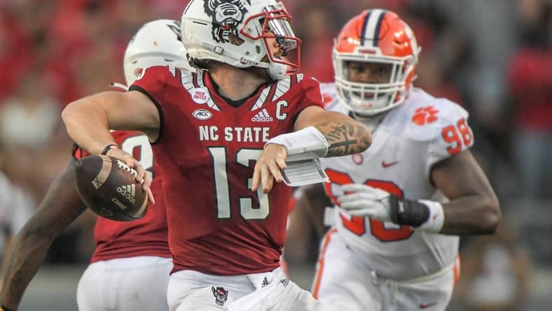 NC State quarterback Devin Leary (13) passes near Clemson defensive end Myles Murphy (98) during the fourth quarter at Carter-Finley Stadium in Raleigh, N.C., September 25, 2021.  The Tigers lost 27-21 in two overtimes game at Carter-Finley Stadium in Raleigh, N.C., September 25, 2021. Leary  was 32-44 for 238  yards and four touchdown passes.

Ncaa Football Clemson At Nc State