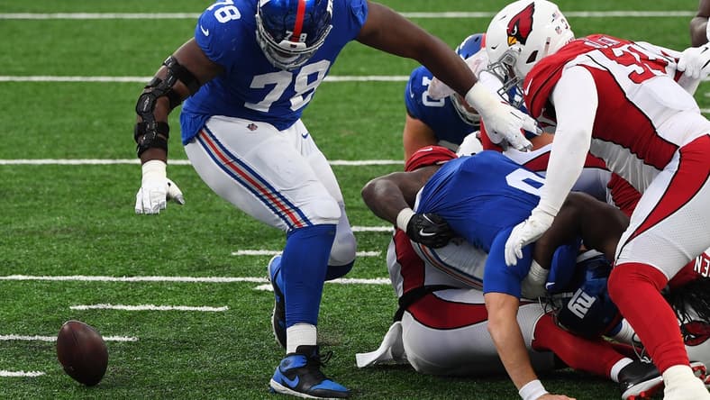 Dec 13, 2020; East Rutherford, New Jersey, USA; New York Giants offensive tackle Andrew Thomas (top) recovers a fumble by quarterback Daniel Jones (8) against Arizona Cardinals defensive end Zach Allen (right) during the second half at MetLife Stadium. Mandatory Credit: Robert Deutsch-USA TODAY Sports