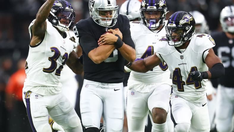 Sep 13, 2021; Paradise, Nevada, USA; Las Vegas Raiders quarterback Marcus Mariota (8) is tackled by Baltimore Ravens defensive back DeShon Elliott (32) and cornerback Marlon Humphrey (44) during the first half at Allegiant Stadium. Mandatory Credit: Mark J. Rebilas-USA TODAY Sports