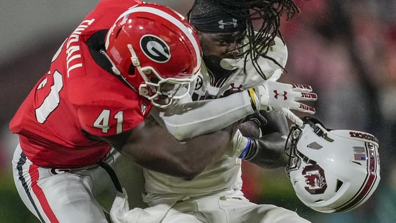 Sep 18, 2021; Athens, Georgia, USA; Georgia Bulldogs linebacker Channing Tindall (41) knocks the helmet of South Carolina Gamecocks wide receiver Dakereon Joyner (5) off on a tackle during the first half at Sanford Stadium. Mandatory Credit: Dale Zanine-USA TODAY Sports