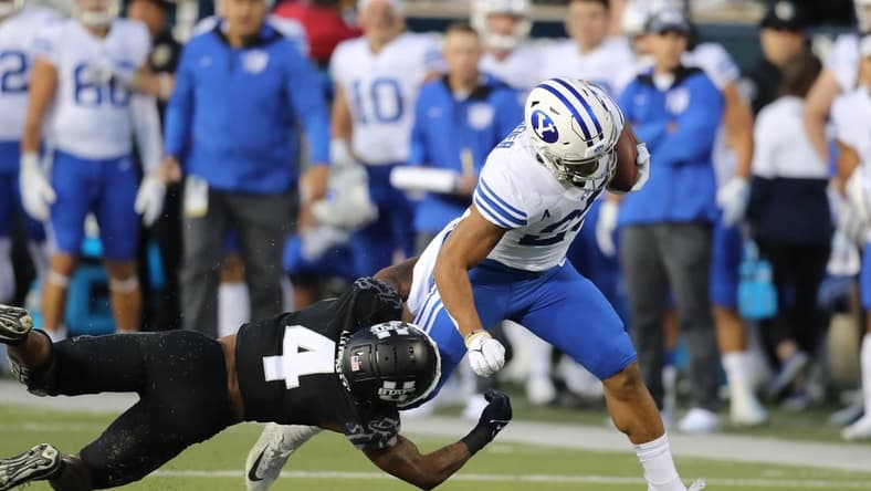 Oct 1, 2021; Logan, Utah, USA; Utah State Aggies running back Calvin Tyler Jr. (4) attempts to tackle Brigham Young Cougars defensive back Talan Alfrey (25) as he runs for a touchdown during the first quarter at Merlin Olsen Field at Maverik Stadium. Mandatory Credit: Rob Gray-USA TODAY Sports