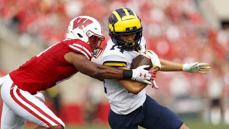 Oct 2, 2021; Madison, Wisconsin, USA; Michigan Wolverines wide receiver Roman Wilson (14) is tackled after catching a pass during the first quarter against the Wisconsin Badgers at Camp Randall Stadium. Mandatory Credit: Jeff Hanisch-USA TODAY Sports