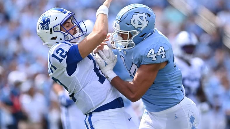 Oct 2, 2021; Chapel Hill, North Carolina, USA; Duke Blue Devils quarterback Gunnar Holmberg (12) is hit by North Carolina Tar Heels linebacker Jeremiah Gemmel (44) as he passes the ball in the second quarter at Kenan Memorial Stadium. Mandatory Credit: Bob Donnan-USA TODAY Sports