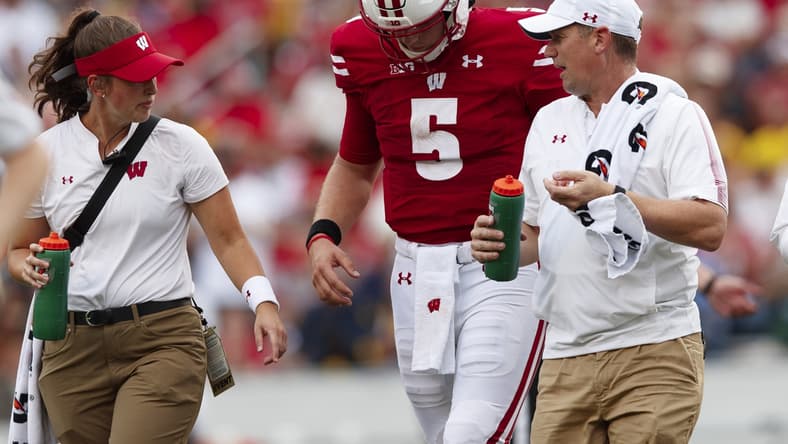 Oct 2, 2021; Madison, Wisconsin, USA; Wisconsin Badgers quarterback Graham Mertz (5) walks from the field after being injured during the third quarter against the Michigan Wolverines at Camp Randall Stadium. Mandatory Credit: Jeff Hanisch-USA TODAY Sports
