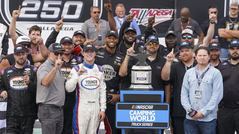 Oct 2, 2021; Talladega Speedway, AL, USA; NASCAR Gander RV and Outdoors Truck Series driver Tate Fogleman (12) holds up the number one as he poses with his team after winning the race at Talladega Speedway. Mandatory Credit: Marvin Gentry-USA TODAY Sports