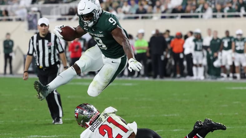 Michigan State Spartans running back Kenneth Walker III jumps over Western Kentucky Hilltoppers defensive back Beanie Bishop on Saturday, Oct. 02, 2021.

Msu Wku