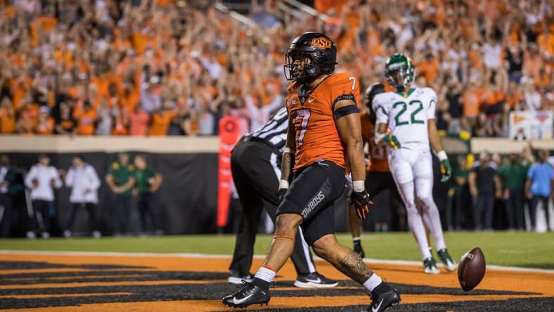 Oct 2, 2021; Stillwater, Oklahoma, USA;  Oct 2, 2021; Stillwater, Oklahoma, USA; Oklahoma State Cowboys running back Jaylen Warren (7) drops the ball after scoring a touchdown during the fourth quarter against the Baylor Bears at Boone Pickens Stadium. OSU won 24-14. Mandatory Credit: Brett Rojo-USA TODAY Sports