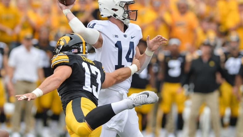 Oct 9, 2021; Iowa City, Iowa, USA; Penn State Nittany Lions quarterback Sean Clifford (14) throws a pass as Iowa Hawkeyes defensive end Joe Evans (13) rushes in during the first quarter at Kinnick Stadium. Mandatory Credit: Jeffrey Becker-USA TODAY Sports