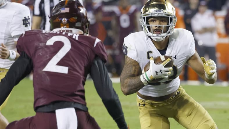Oct 9, 2021; Blacksburg, Virginia, USA;  Notre Dame Fighting Irish running back Kyren Williams (23) runs the ball toward Virginia Tech Hokies defensive back Jermaine Waller (2) during the second quarter at Lane Stadium. Mandatory Credit: Reinhold Matay-USA TODAY Sports