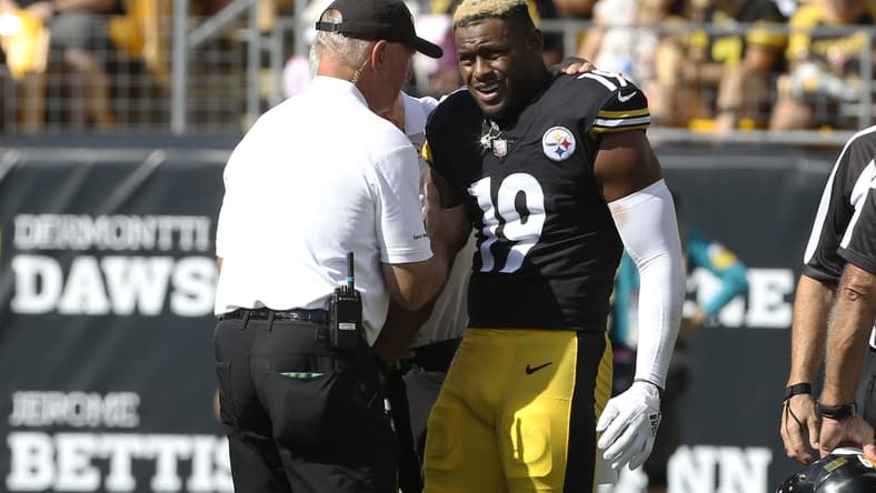 Oct 10, 2021; Pittsburgh, Pennsylvania, USA;  Pittsburgh Steelers team orthopedic doctor James Bradley (left) looks at the right arm of Pittsburgh Steelers wide receiver JuJu Smith-Schuster (19) after Smith-Schuster suffered an apparent injury against the Denver Broncos during the second quarter at Heinz Field. Smith-Schuster  would leave the game. Mandatory Credit: Charles LeClaire-USA TODAY Sports