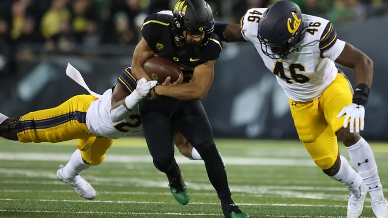 Oct 15, 2021; Eugene, Oregon, USA; Oregon Ducks running back Travis Dye (26) fights for extra yards against California Golden Bears linebacker Marqez Bimage (46) at Autzen Stadium. Mandatory Credit: Jaime Valdez-USA TODAY Sports
