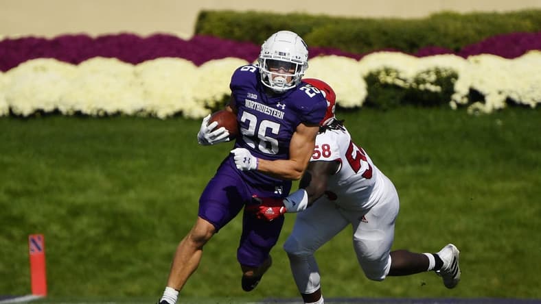 Oct 16, 2021; Evanston, Illinois, USA; Northwestern Wildcats running back Evan Hull (26) runs with the football in the first half against Rutgers Scarlet Knights linebacker Mohamed Toure (58) at Ryan Field. Mandatory Credit: Quinn Harris-USA TODAY Sports