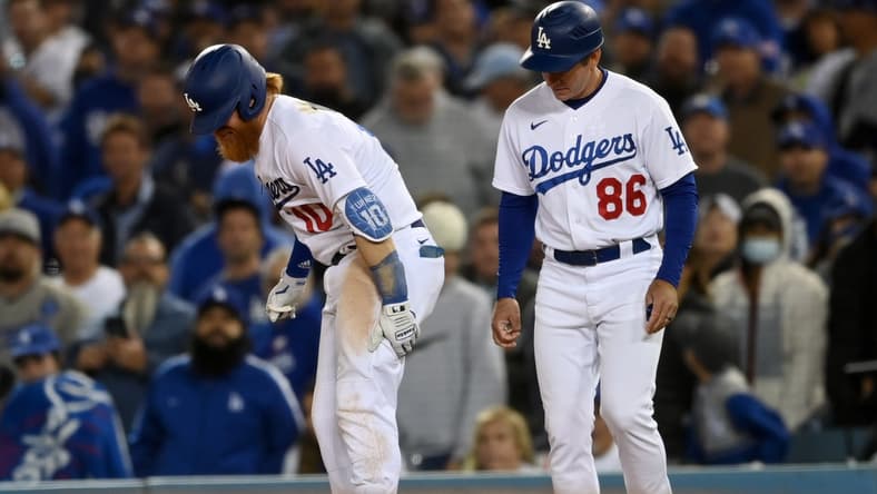 Oct 20, 2021; Los Angeles, California, USA; Los Angeles Dodgers third baseman Justin Turner (10) reacts with first base coach Clayton McCullough (86) after an injury in the seventh inning against the Atlanta Braves during game four of the 2021 NLCS at Dodger Stadium. Mandatory Credit: Jayne Kamin-Oncea-USA TODAY Sports