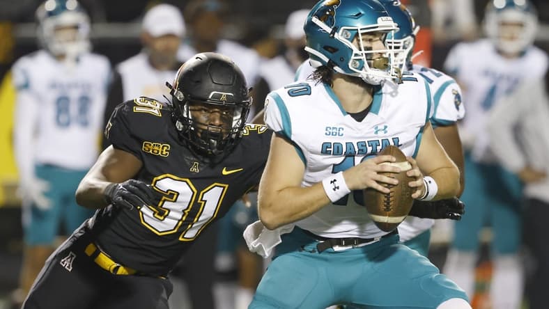 Oct 20, 2021; Boone, North Carolina, USA; Appalachian State Mountaineers linebacker Nick Hampton (31) catches Coastal Carolina Chanticleers quarterback Grayson McCall (10) and sacks him during the second half at Kidd Brewer Stadium. Mandatory Credit: Reinhold Matay-USA TODAY Sports