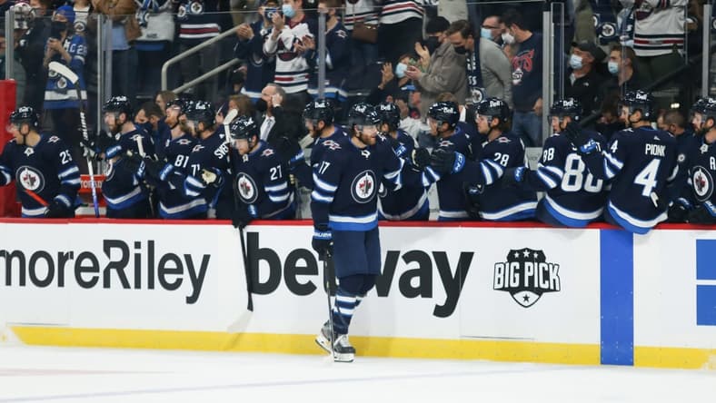 Oct 23, 2021; Winnipeg, Manitoba, CAN;  Winnipeg Jets forward Adam Lowry (17) is congratulated by his team mates on his goal against the Nashville Predators during the first period at Canada Life Centre. Mandatory Credit: Terrence Lee-USA TODAY Sports