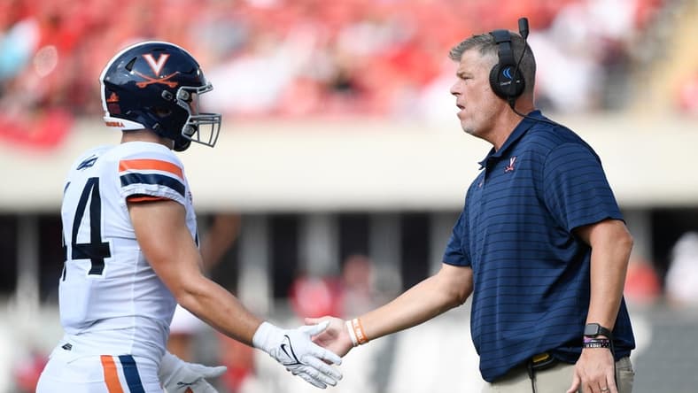 Oct 9, 2021; Louisville, Kentucky, USA;  Virginia Cavaliers head coach Bronco Mendenhall congratulates Virginia Cavaliers tight end Sackett Wood Jr. (44) following a play against the Louisville Cardinals during the first half at Cardinal Stadium. Virginia defeated Louisville 34-33. Mandatory Credit: Jamie Rhodes-USA TODAY Sports