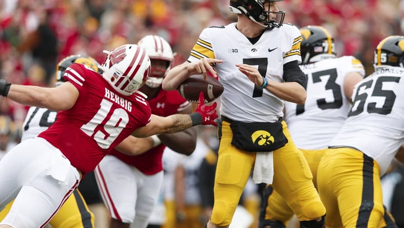 Oct 30, 2021; Madison, Wisconsin, USA; Wisconsin Badgers linebacker Nick Herbig (19) strips the ball away from Iowa Hawkeyes quarterback Spencer Petras (7) during the second quarter at Camp Randall Stadium. Mandatory Credit: Jeff Hanisch-USA TODAY Sports