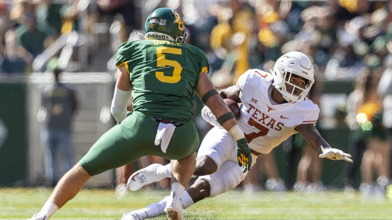 Oct 30, 2021; Waco, Texas, USA; Texas Longhorns running back Keilan Robinson (7) looks for yards past Baylor Bears linebacker Dillon Doyle (5) in the first half of an NCAA football game at McLane Stadium. Mandatory Credit: Stephen Spillman-USA TODAY Sports