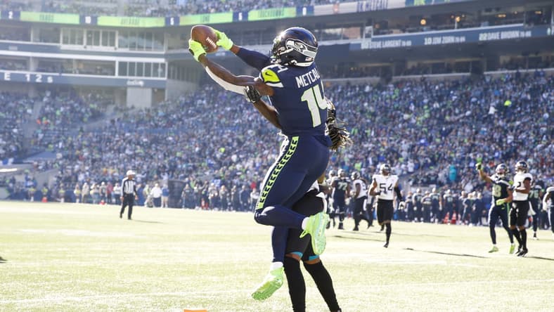 Oct 31, 2021; Seattle, Washington, USA; Seattle Seahawks wide receiver DK Metcalf (14) catches a touchdown pass against Jacksonville Jaguars cornerback Shaquill Griffin (26) during the second quarter at Lumen Field. Mandatory Credit: Joe Nicholson-USA TODAY Sports