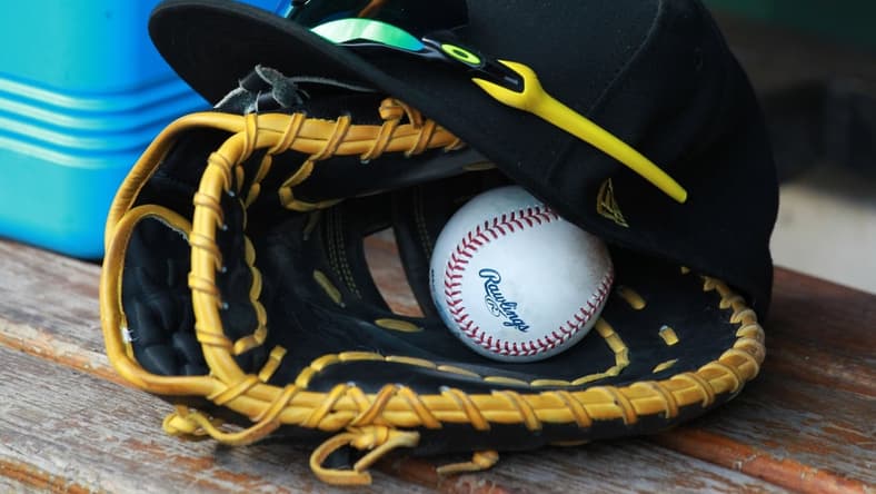 Jul 28, 2018; Pittsburgh, PA, USA; A Pittsburgh Pirates glove and cap are seen in the dugout during a game against the New York Mets at PNC Park. Mandatory Credit: Charles LeClaire-USA TODAY Sports