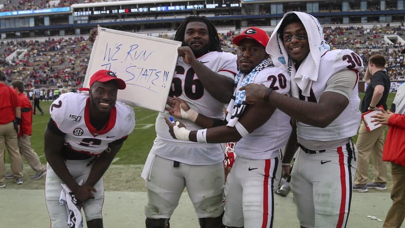 Nov 30, 2019; Atlanta, GA, USA; Georgia Bulldogs defensive back Richard LeCounte (2) and offensive lineman Solomon Kindley (66) and defensive back J.R. Reed (20) and linebacker Tae Crowder (30) celebrate against the Georgia Tech Yellow Jackets in the second half at Bobby Dodd Stadium. Mandatory Credit: Brett Davis-USA TODAY Sports