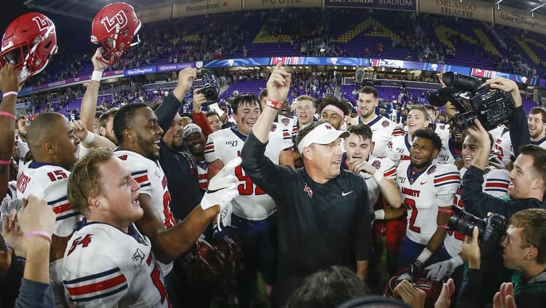 Dec 21, 2019; Orlando, Florida, USA; Liberty Flames head coach Hugh Freeze (middle) celebrates with his team after winning the Cure Bowl  against Georgia the Southern Eagles at Exploria Stadium. Mandatory Credit: Reinhold Matay-USA TODAY Sports