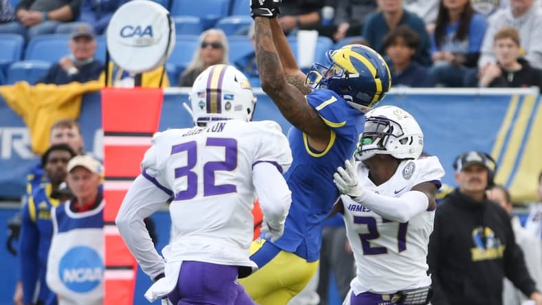 Delaware receiver Thyrick Pitts (1) pulls in a pass between James Madison's MJ Hampton (32) and Taurus Carroll in the second quarter at Delaware Stadium, Saturday, Oct. 23, 2021.

Ud V Jmu