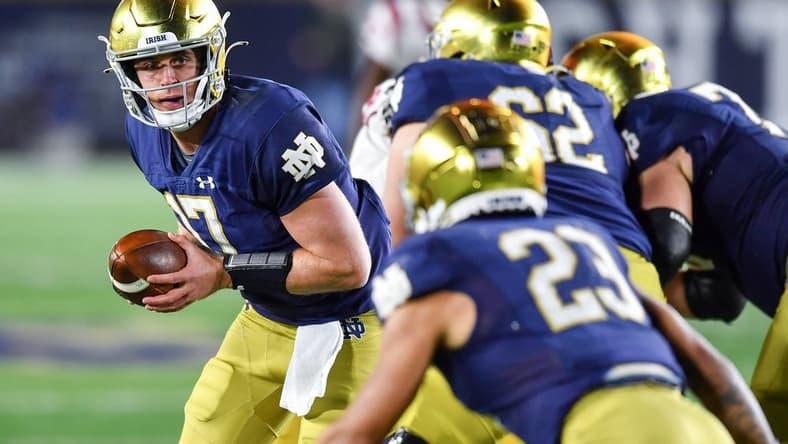 Oct 23, 2021; South Bend, Indiana, USA; Notre Dame Fighting Irish quarterback Jack Coan (17) looks to hand off to running back Kyren Williams (23) in the third quarter against the USC Trojans at Notre Dame Stadium. Mandatory Credit: Matt Cashore-USA TODAY Sports